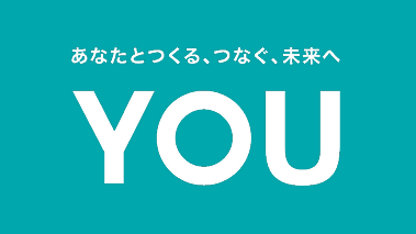 「あなたとつくる、つなぐ、未来へ」のコピーと大きく「YOU」と記されたブランドビジュアル。