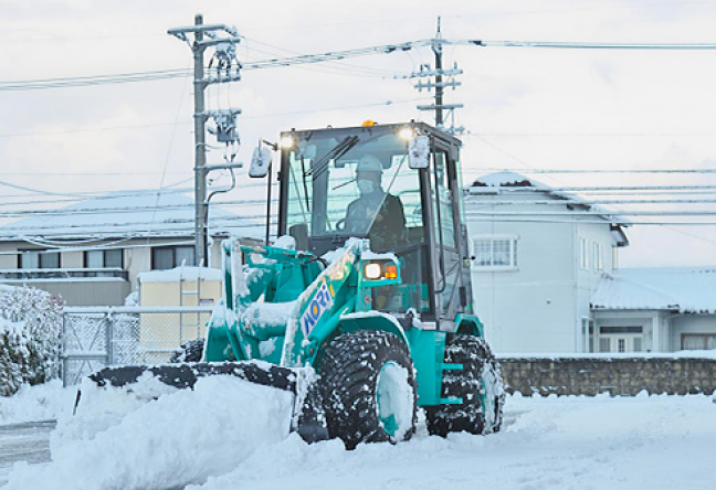 除雪アタッチメントを装着したミニホイールローダ